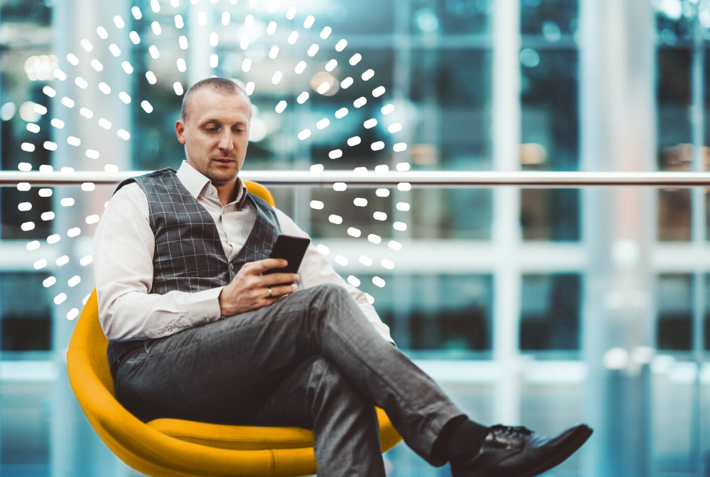 Businessman sitting in a chair on his smartphone