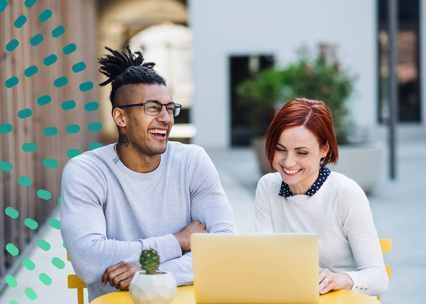 Man and Woman outside on a laptop laughing